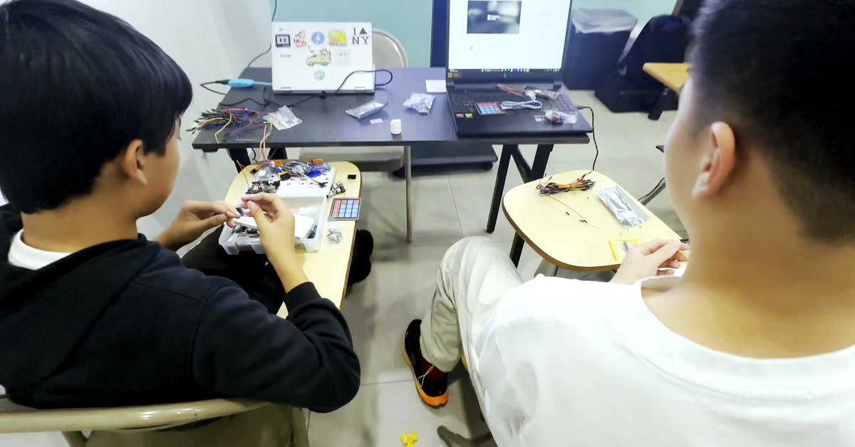 Students building and coding robotics projects in class